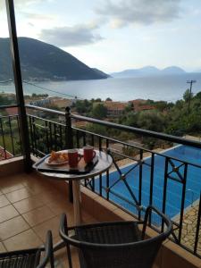 a balcony with a table and a view of the water at Katerina Lefkada in Vasiliki