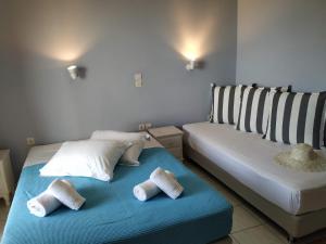 a hotel room with two beds and two lamps at Katerina Lefkada in Vasiliki