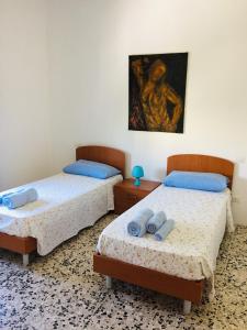 2 Betten in einem Zimmer mit Wandgemälde in der Unterkunft Salento Appartamenti in Casalabate