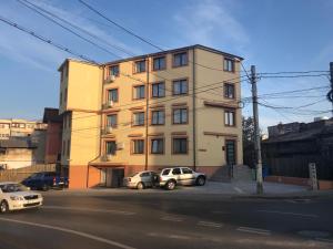 een gebouw met twee auto's ervoor geparkeerd bij Luxury Desing Apartment in Piteşti