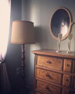 een slaapkamer met een dressoir, een lamp en een spiegel bij Il Nido exclusive apartment Parma in Parma
