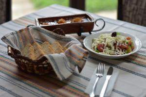 una mesa con un plato de comida y un tazón de ensalada en Family Hotel Balkana, en Apriltsi