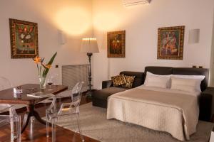 a bedroom with a bed and a couch and a table at Riccardo Condotti Suite in Rome