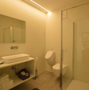 a bathroom with a toilet and a sink and a shower at Family Apartment Julia in Termeno