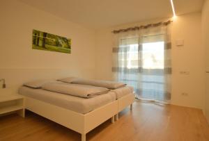 a room with two beds in it with a window at Family Apartment Julia in Termeno