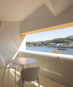 a room with a table and chairs and a large window at LeBlanche in Porto