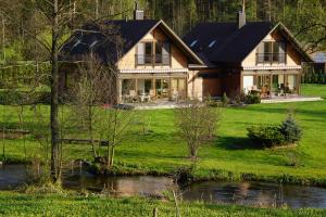 a house with a river in front of it at Atostogų namelis Druskininkuose in Druskininkai