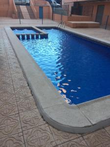 Acogedor y novedoso Loft en Torrevieja في توريفايجا: مسبح بمياه زرقاء في مبنى