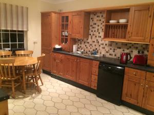cocina con armarios de madera, mesa, mesa y sillas en Ballydevitt Retreat en Donegal