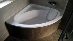 a white bath tub with a shower in a bathroom at Neue Fewo in perfekter Lage (Limburg a. d. Lahn) in Limburg an der Lahn +16 photos