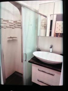 a bathroom with a white sink and a shower at Apartmán Kocka na prízemí in Šaštín +36 photos