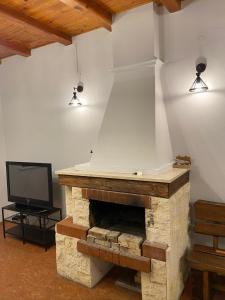 sala de estar con chimenea de piedra y TV en Willa Chańcza, en Chańcza