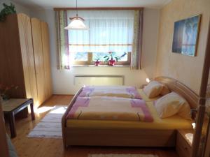 1 dormitorio con cama y ventana en Ferienwohnung Maier, en Flattach