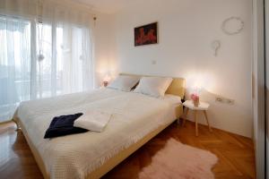 een slaapkamer met een groot wit bed en een raam bij LindaMaria in Rijeka