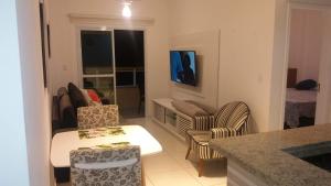a living room with a couch and a table and chairs at Praia Grande - Edifício Frente ao Mar in Praia Grande