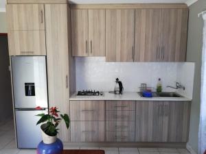 uma cozinha com armários de madeira e um frigorífico branco em Glentana Silver Moon Self Catering em Glentana