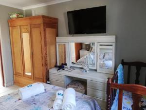 um quarto com uma televisão e um armário branco em Glentana Silver Moon Self Catering em Glentana