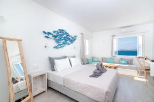 a white bedroom with a bed and a mirror at Sea House in Naousa