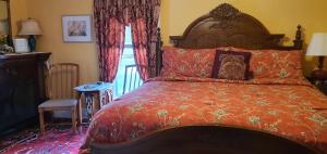 a bedroom with a large bed with an orange comforter at A Moment in Time Bed and Breakfast in Niagara Falls