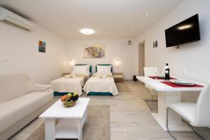 une chambre d'hôtel avec deux lits et un canapé dans l'établissement Apartments Maraton, à Split