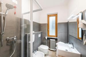 a bathroom with a sink and a toilet and a shower at Hotel Argegno in Argegno