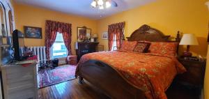 1 dormitorio con 1 cama y TV en A Moment in Time Bed and Breakfast, en Niagara Falls