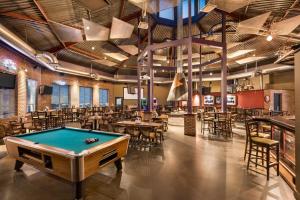 - un billard dans un restaurant avec des tables et des chaises dans l'établissement Royal Hotel Edmonton Airport Trademark Collection By Wyndham, à Leduc