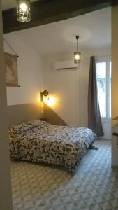 a bedroom with a bed and a window at Mauguio Center Hôtel in Mauguio