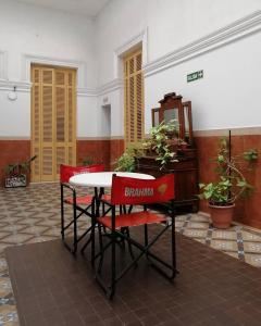 a table and two red chairs in a room at Hotel La Piedad in Buenos Aires
