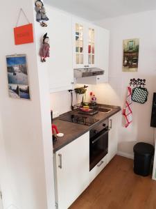 een keuken met witte kasten en een zwarte oven bij Apartment Kleiner Heinrich in Braunlage