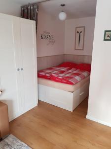 Apartment Kleiner Heinrich في برونلاغ: غرفة نوم بسرير ولحاف احمر