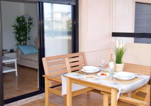 a dining room table and chairs with a table and a glass door at The Blue Torrent, perfect for relaxing getaway in La Oliva