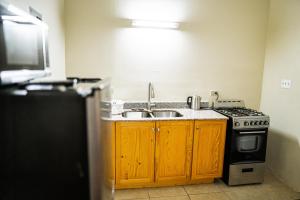 a kitchen with a sink and a stove at Connie's Comfort Suites in Saint Johnʼs