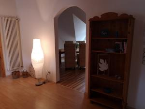 a living room with a lamp and a book shelf at Casa Mosella in Enkirch