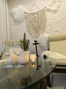 a glass table with two wine glasses and a candle at Rooms Apartments in Samara