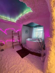 a room with a tub in a room with pink lights at Rooms Apartments in Samara