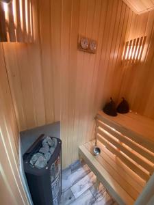 a sauna with a bench and a trash can at Rooms Apartments in Samara