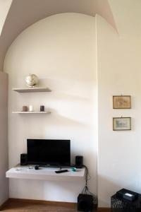 un salon avec une télévision sur un mur blanc dans l'établissement Via Giotto, 5, à Assise 31 autres photos