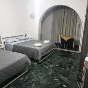 una camera con due letti e un tavolo con specchio di B&B GANAJ - Corso Italia 89 - BARI a Bari