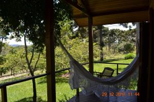 a hammock on the porch of a house at Pousada Candeias in Cunha