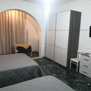 ein Schlafzimmer mit einem Bett, einer Kommode und einem Tisch in der Unterkunft B&B GANAJ - Corso Italia 89 - BARI in Bari