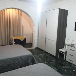a bedroom with a bed and a dresser and a table at B&B GANAJ - Corso Italia 89 - BARI in Bari