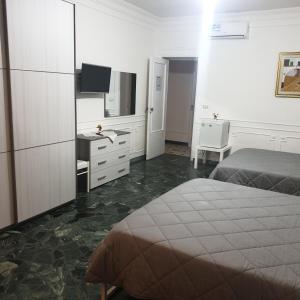 a bedroom with a bed and a desk and a television at B&B GANAJ - Corso Italia 89 - BARI in Bari