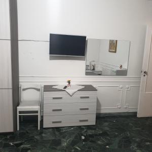 bagno con cassettiera, specchio e lavandino di B&B GANAJ - Corso Italia 89 - BARI a Bari
