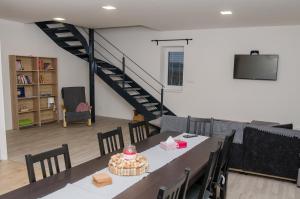 a room with a table with chairs and a staircase at Vinný sklep u Malíků in Drnholec