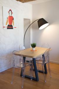 a dining room table with chairs and a lamp at Appartement A-Mi-Chemin - Centre-ville de Tournus in Tournus