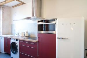 a kitchen with a refrigerator and a washing machine at Appartement A-Mi-Chemin - Centre-ville de Tournus in Tournus