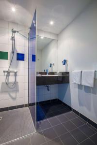 a bathroom with a sink, toilet and shower stall at Park Inn by Radisson Frankfurt Airport in Frankfurt