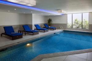 a pool in a hotel room with blue chairs at SAS Residence & Hotel Dhahran in Al Khobar