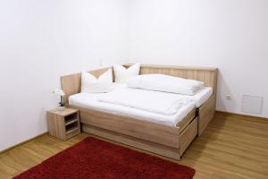 1 dormitorio con cama de madera y alfombra roja en Ferienwohnung am Westerturm en Duderstadt